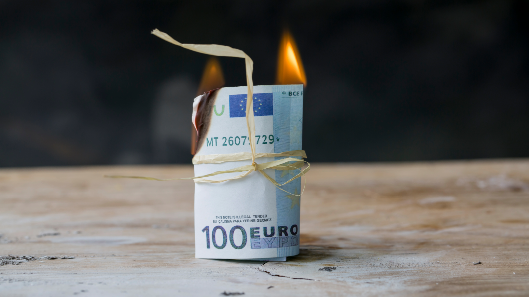 Symbolbild: Eine Rolle brennender 100€-Scheine 