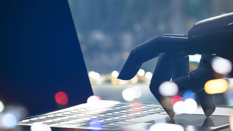 Roboter Hand schreibt am Laptop 